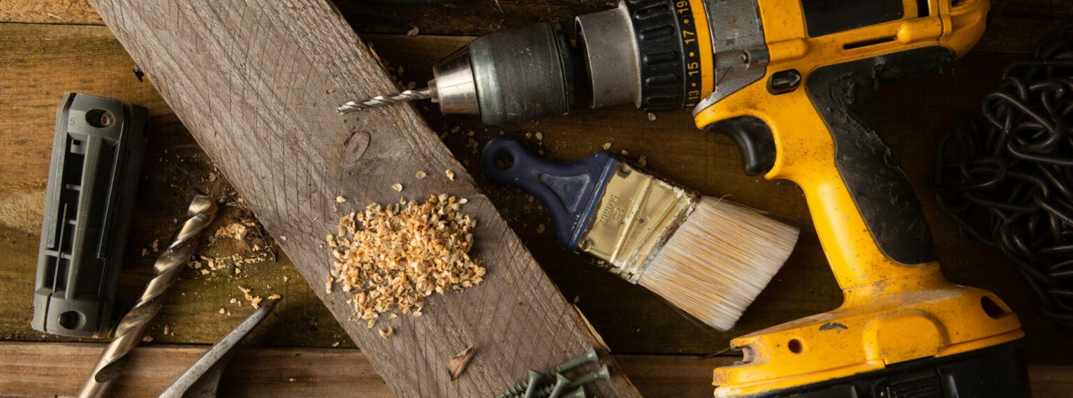 drill on table with saw dust and bits